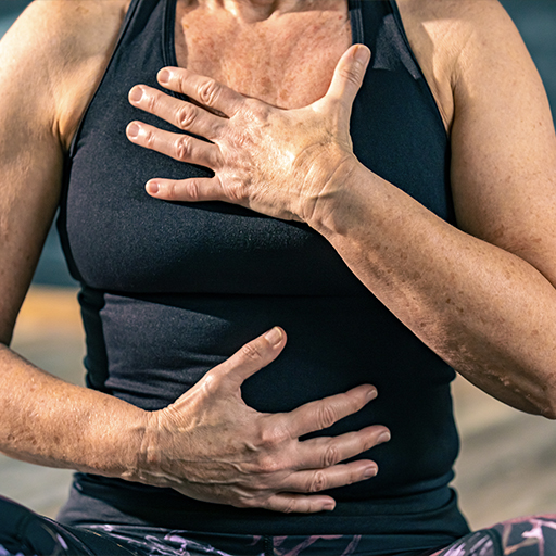 Yoga leerling met handen op haar borst en buik voor een gecontroleerde admenhaling